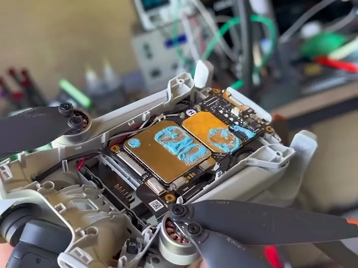 A DJI drone opened up mid-repair, mainboard exposed