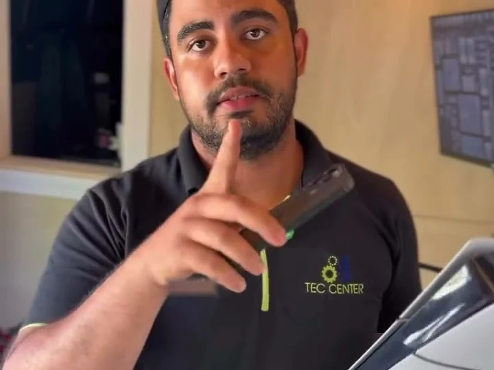 A TEC CENTER technician in a branded polo shirt inside the van